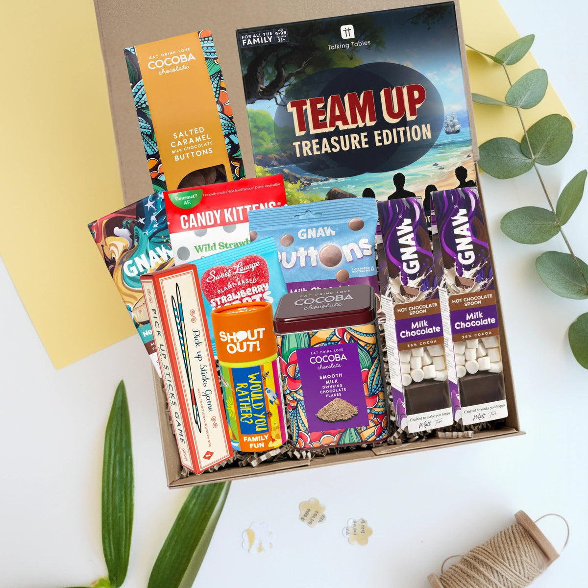 Assorted candy and chocolate bars in a box with 'Team Up' game and classic family games in a gift box hamper