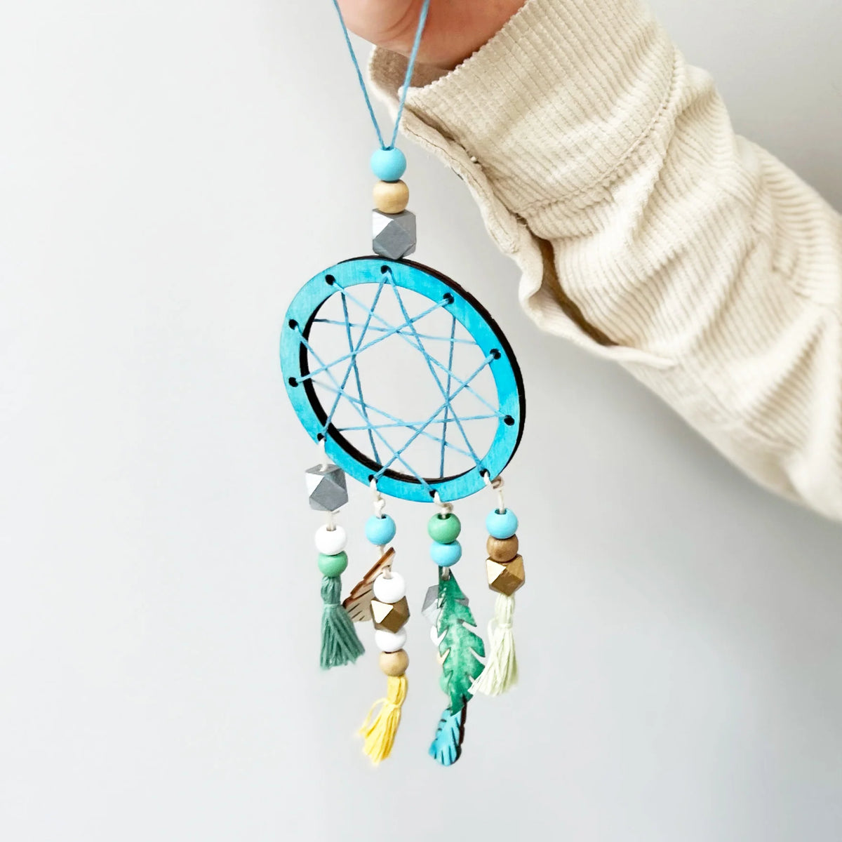child holding a dream catcher made with the Cotton Twist Make Your Own Dreamcatcher Craft Kit 
