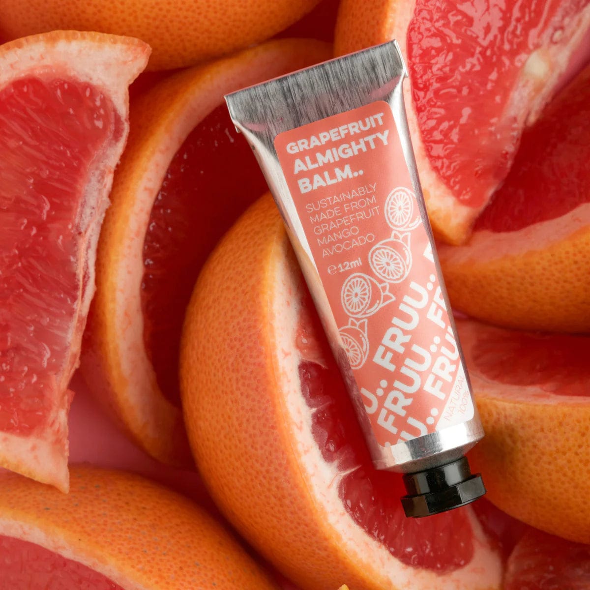 FRUU All Purpose Balm Grapefruit Almighty Balm in an aluminium tube. The balm is picture on top of fresh sliced grapefruits. 