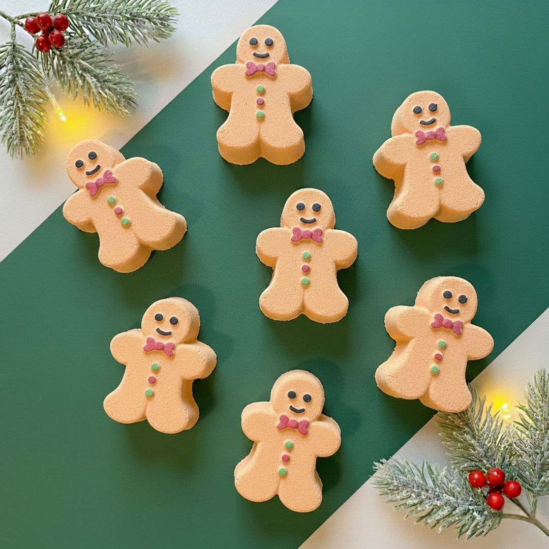 7 gingerbread man bath bombs on a green background with festive branches