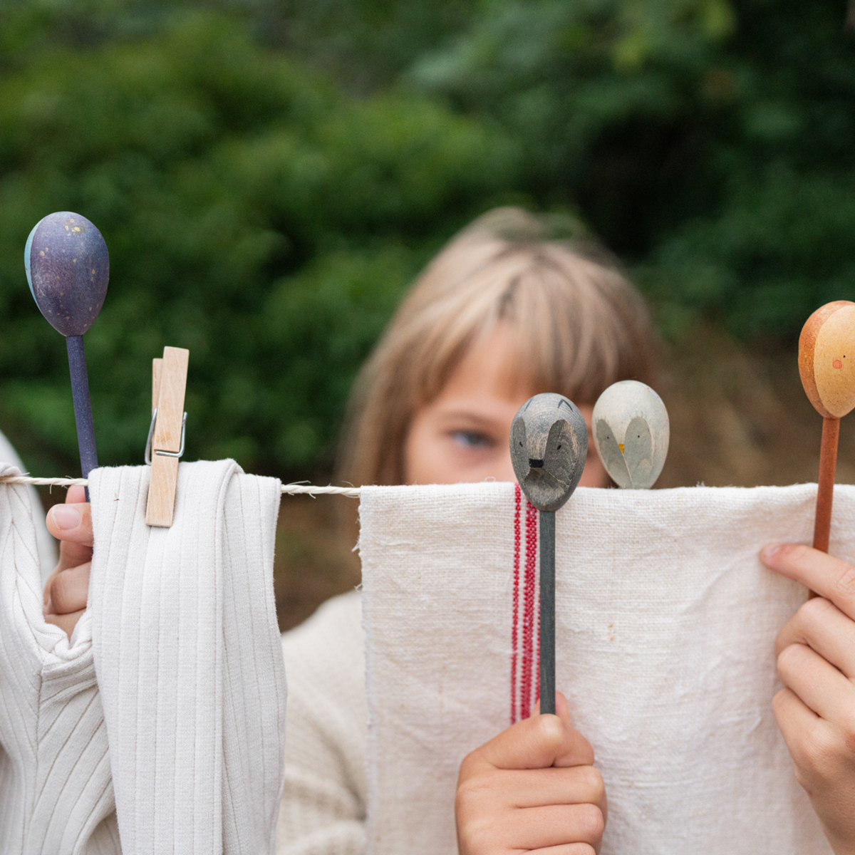 girls playing with grapat twin soul wooden puppets in earth tones with double sided faces. 