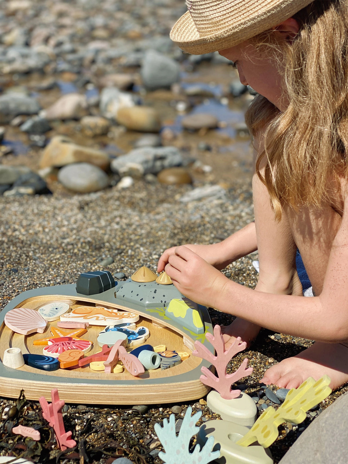girl playing with Tender Leaf My Little Rockpool play set with wooden marine creatures and plants. Age 3+ 