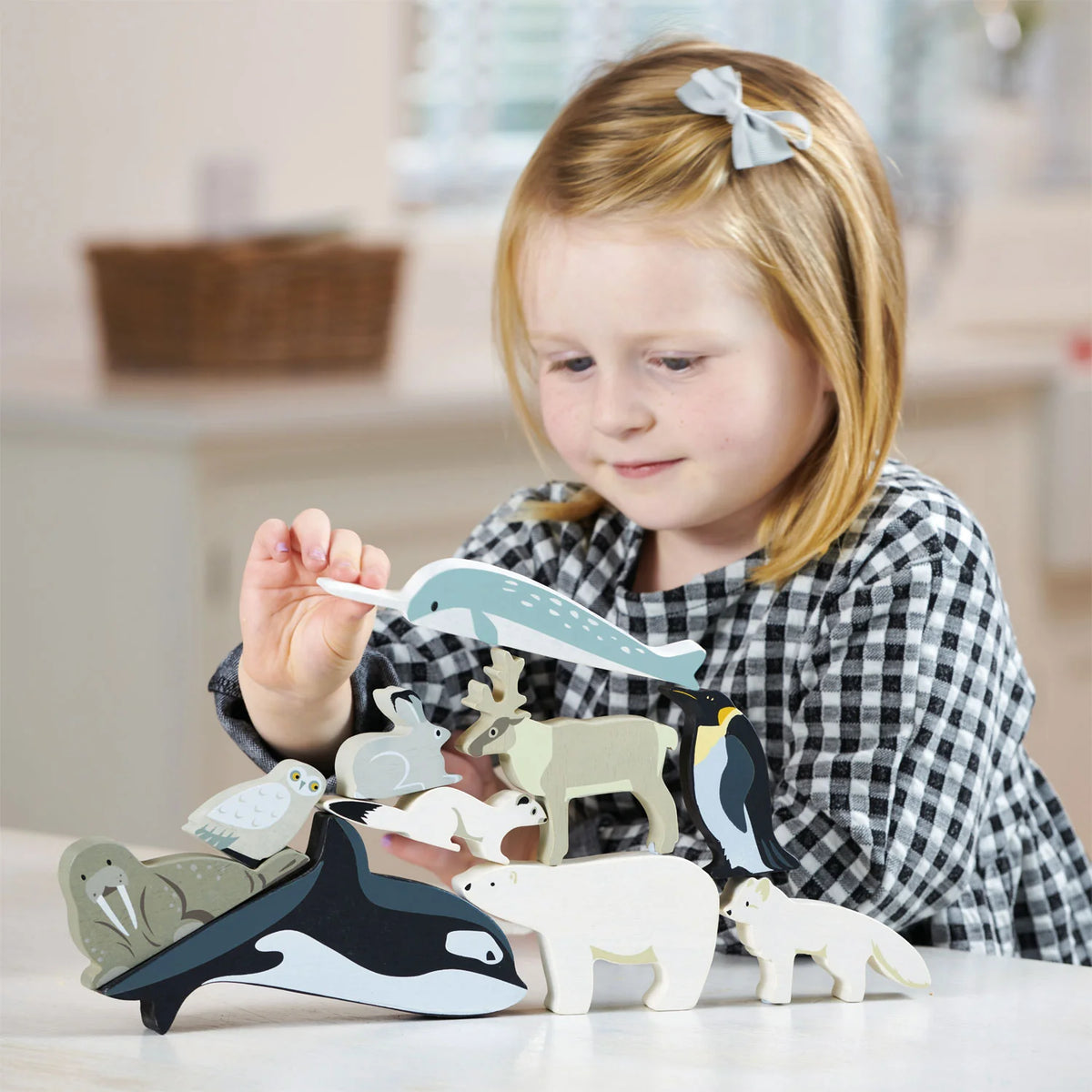 girl playing with Tender Leaf Polar Animals - killer whale, narwal, snow hare, arctic fox, king penguin, owl, white stoat, an elk and of course a polar bear.