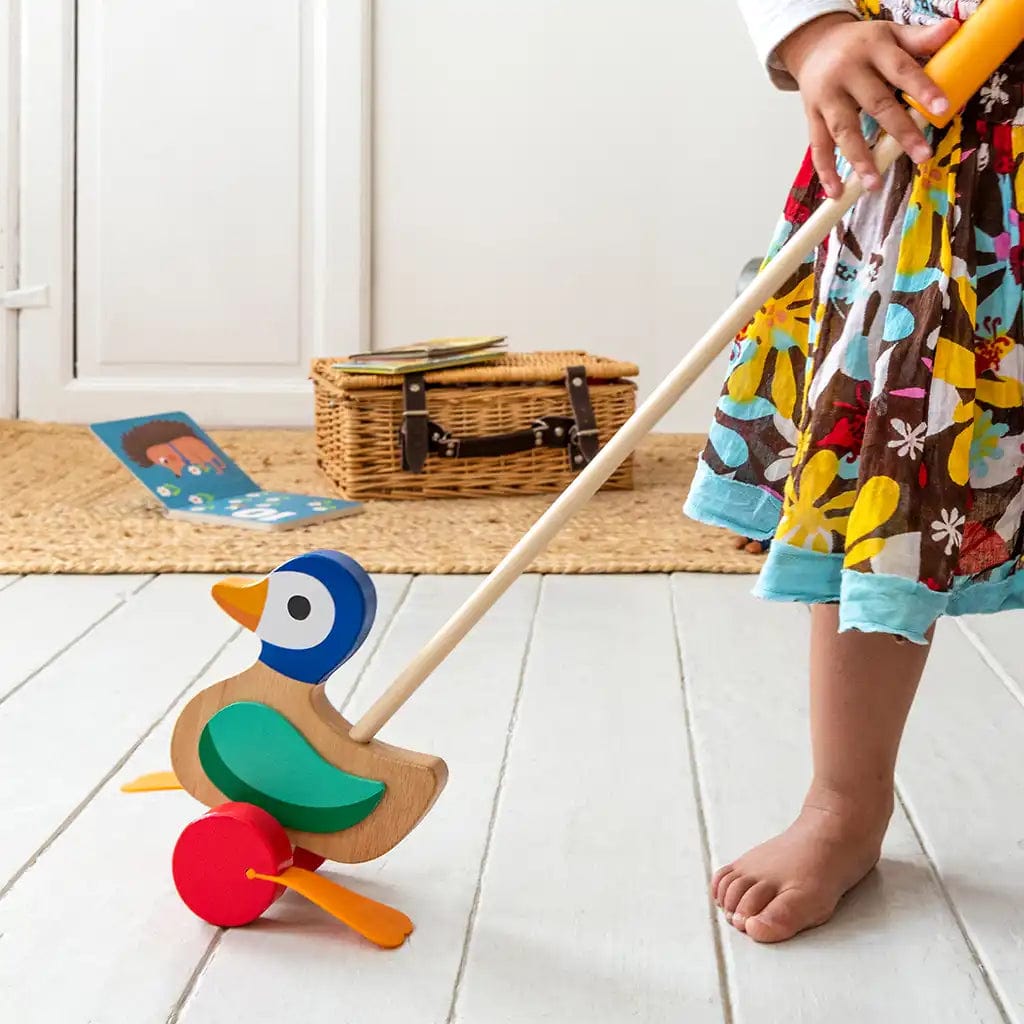 child pushing a wooden duck push along toy by rex london. For age 3 and over