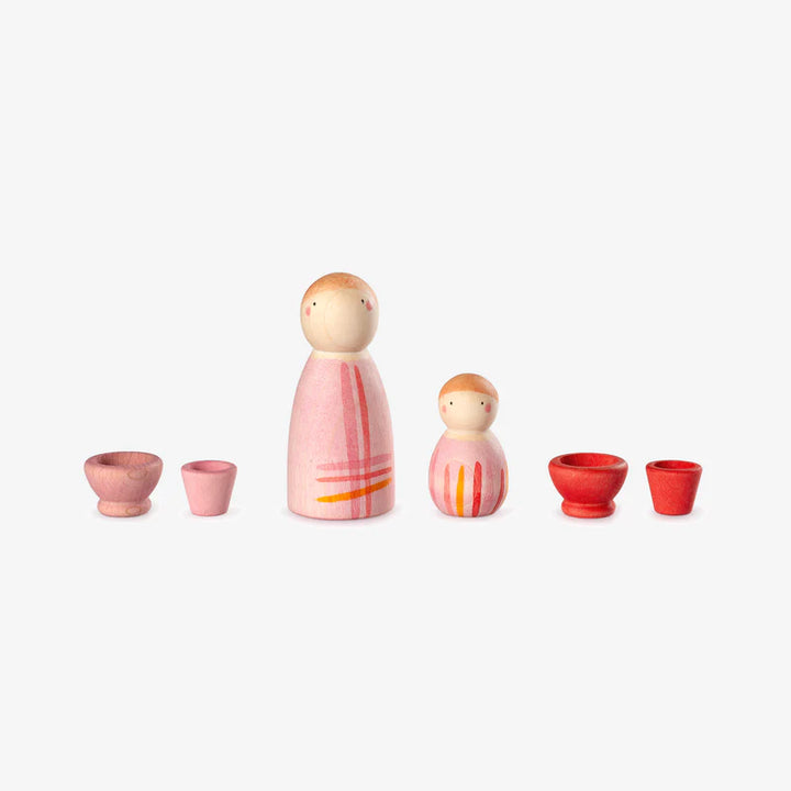Set of wooden peg dolls with colourful patterns and small red and pink bowls on a white background. An example of a Grapat Lucky Lucky 4th edition box contents