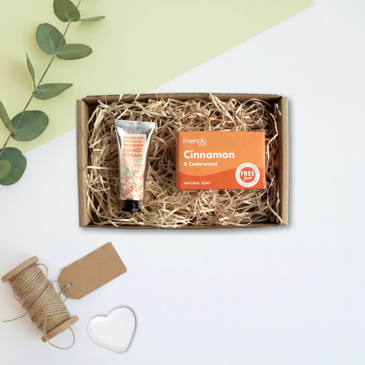 Box of hand cream and soap with a decorative tag and twine on a light background