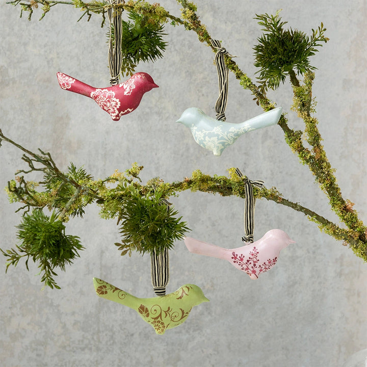 Decorative bird ornaments on a branch with a textured background