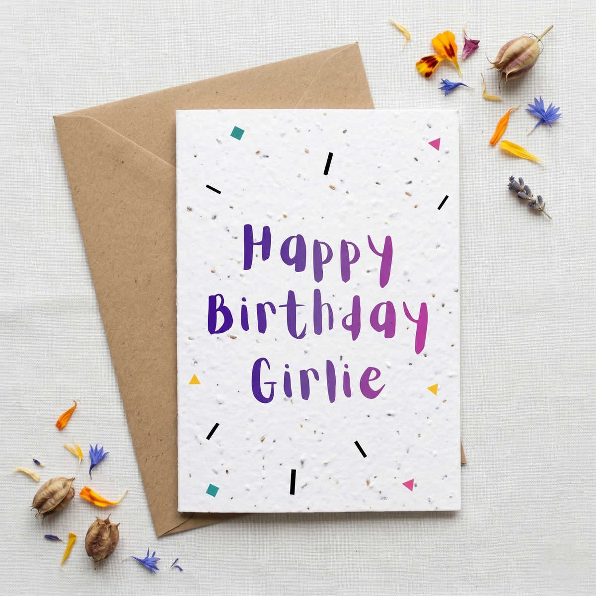Birthday card with 'Happy Birthday Girlie' text on a white background with decorative elements.