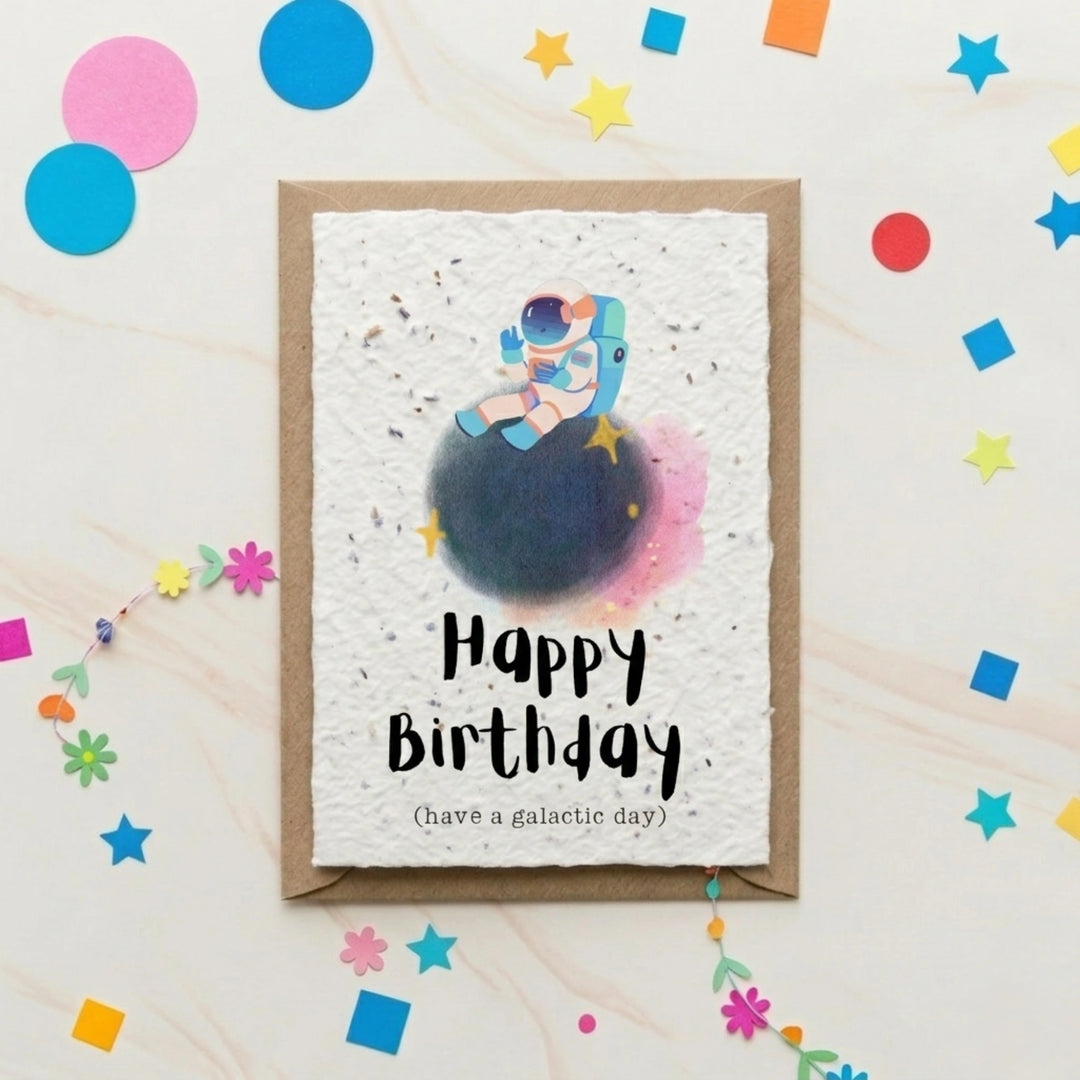Birthday card with an astronaut design and colorful confetti on a light background