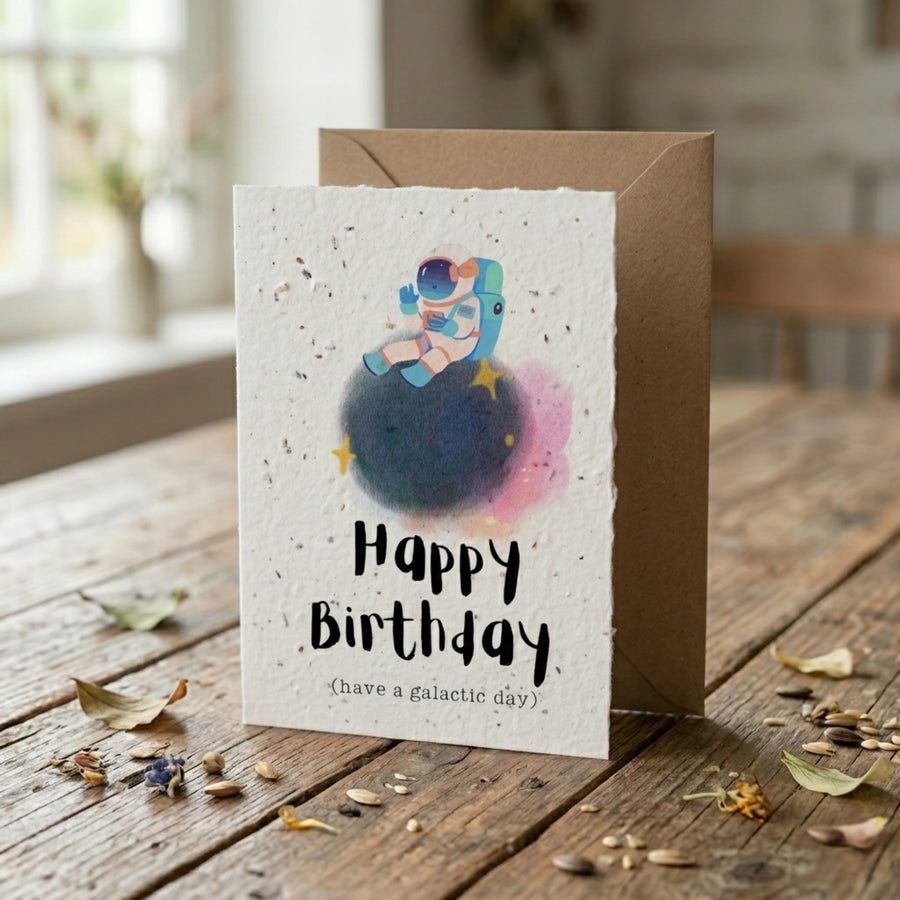 Birthday card with space-themed illustration on a wooden table