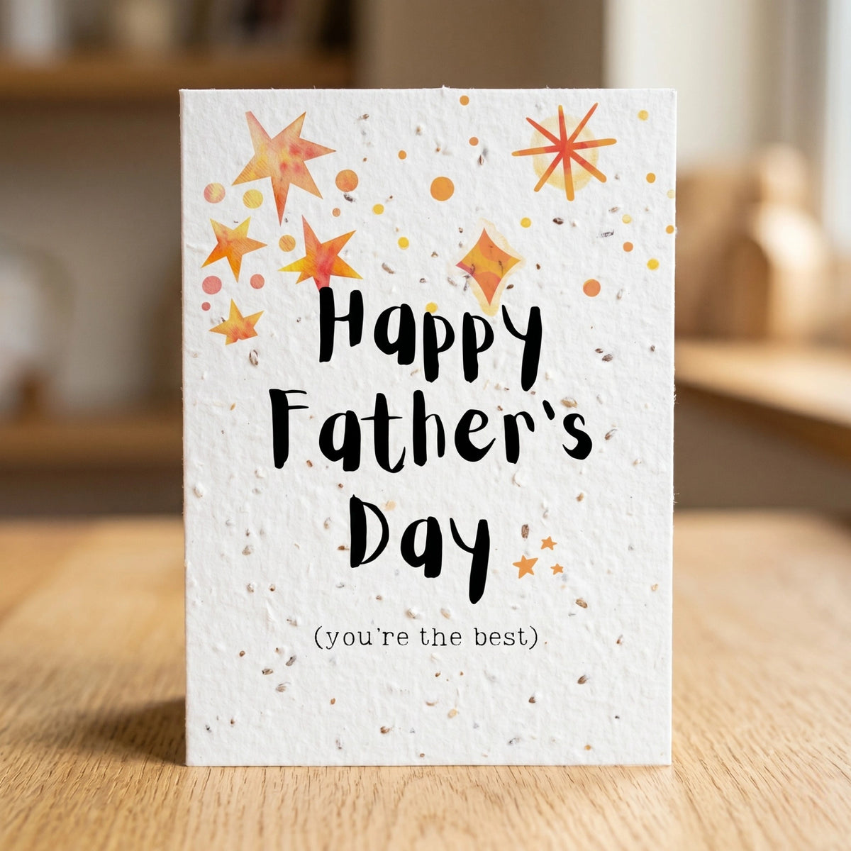 Father's Day card with stars and 'Happy Father's Day (you're the best)' text on a wooden surface.