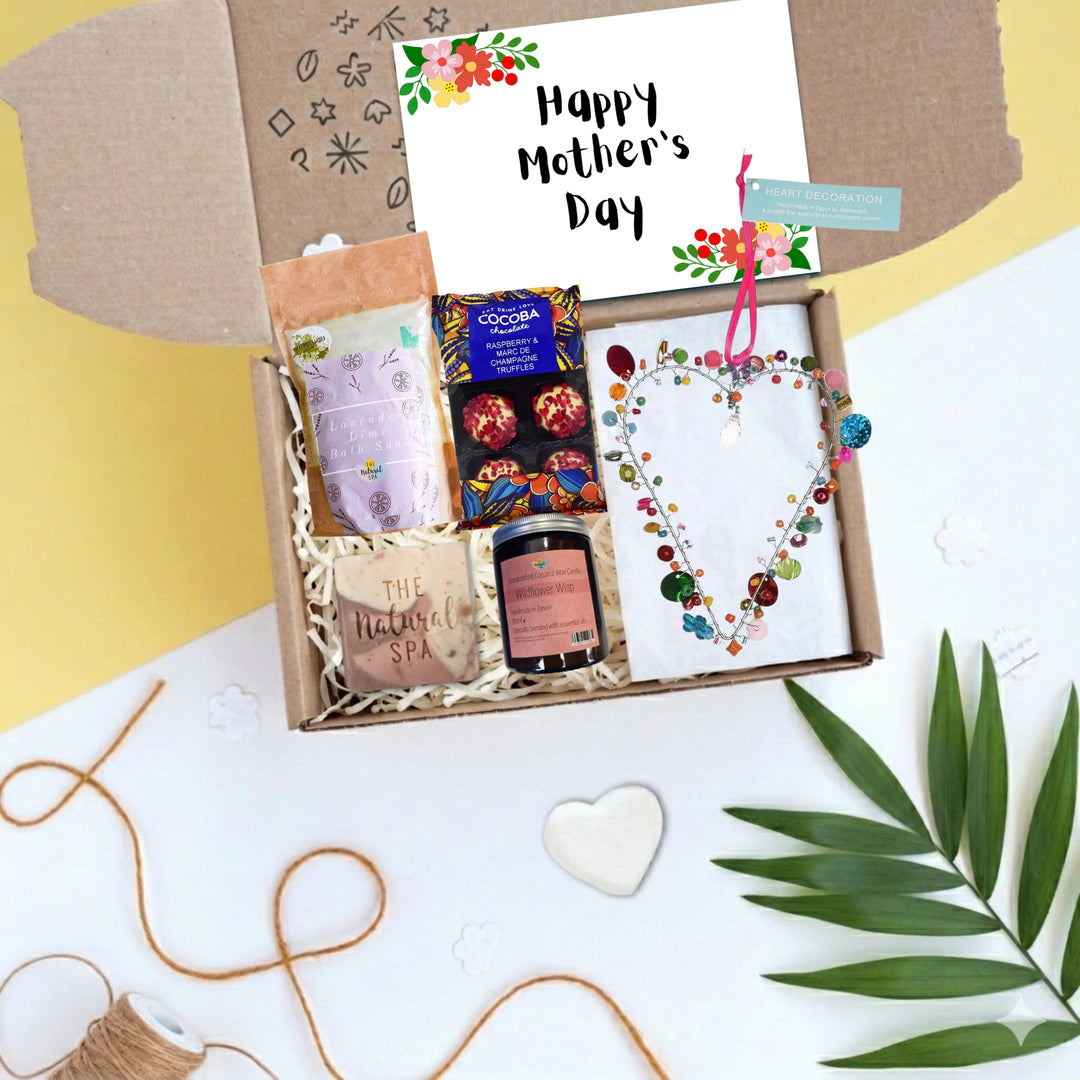 happy mothers day gift box with chocolates, body care products and a colourful beaded heart decoration. There is a card which reads 'Happy Mother's Day'