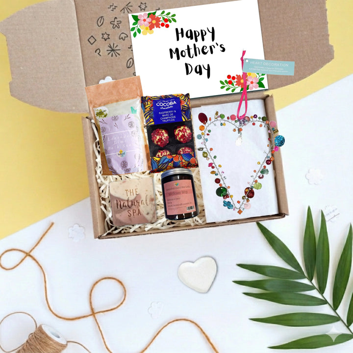 happy mothers day gift box with chocolates, body care products and a colourful beaded heart decoration. There is a card which reads 'Happy Mother's Day'