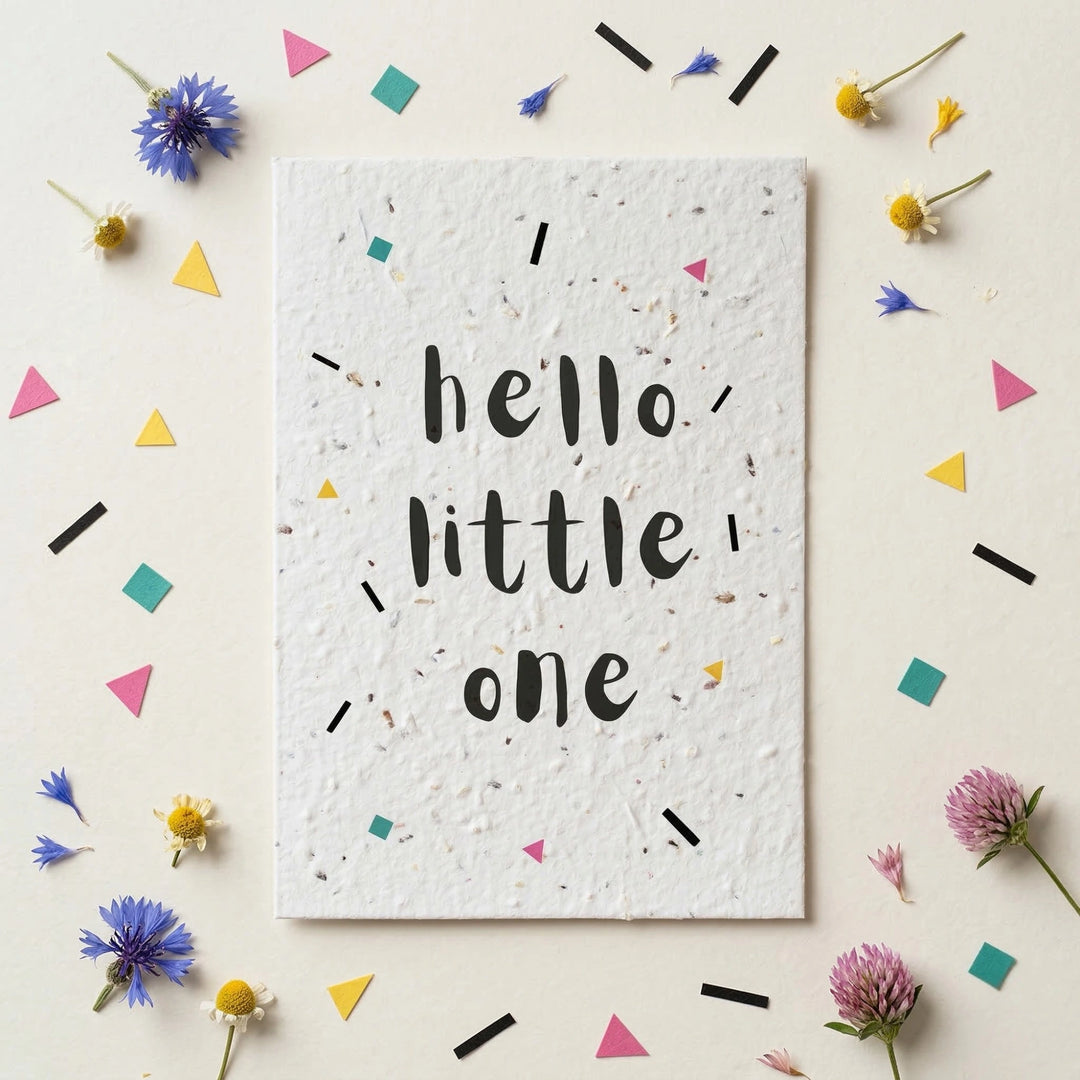 Card with 'hello little one' text on a decorative background with flowers and confetti.