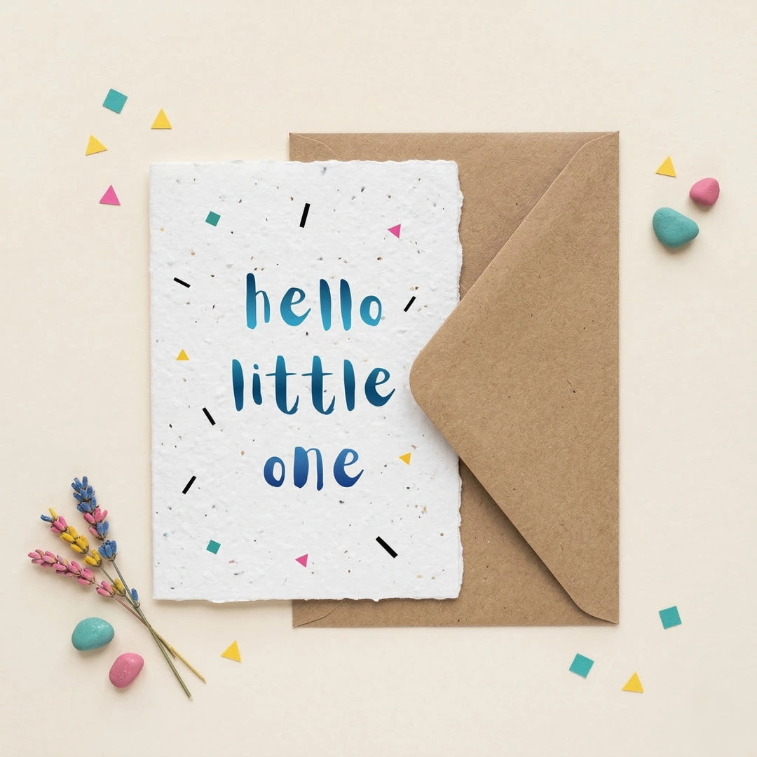 Greeting card with 'hello little one' text on a white background with a brown envelope and decorative elements.