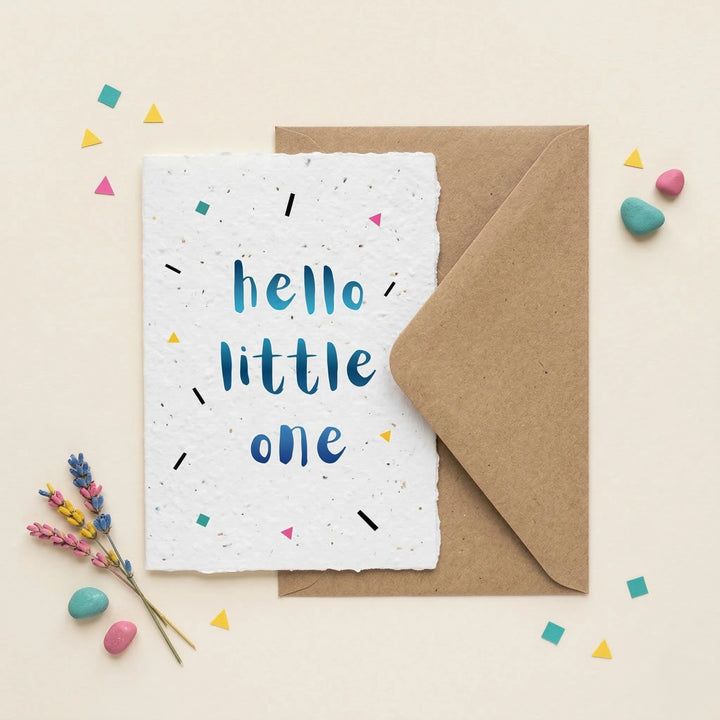 Greeting card with 'hello little one' text on a white background with a brown envelope and decorative elements.