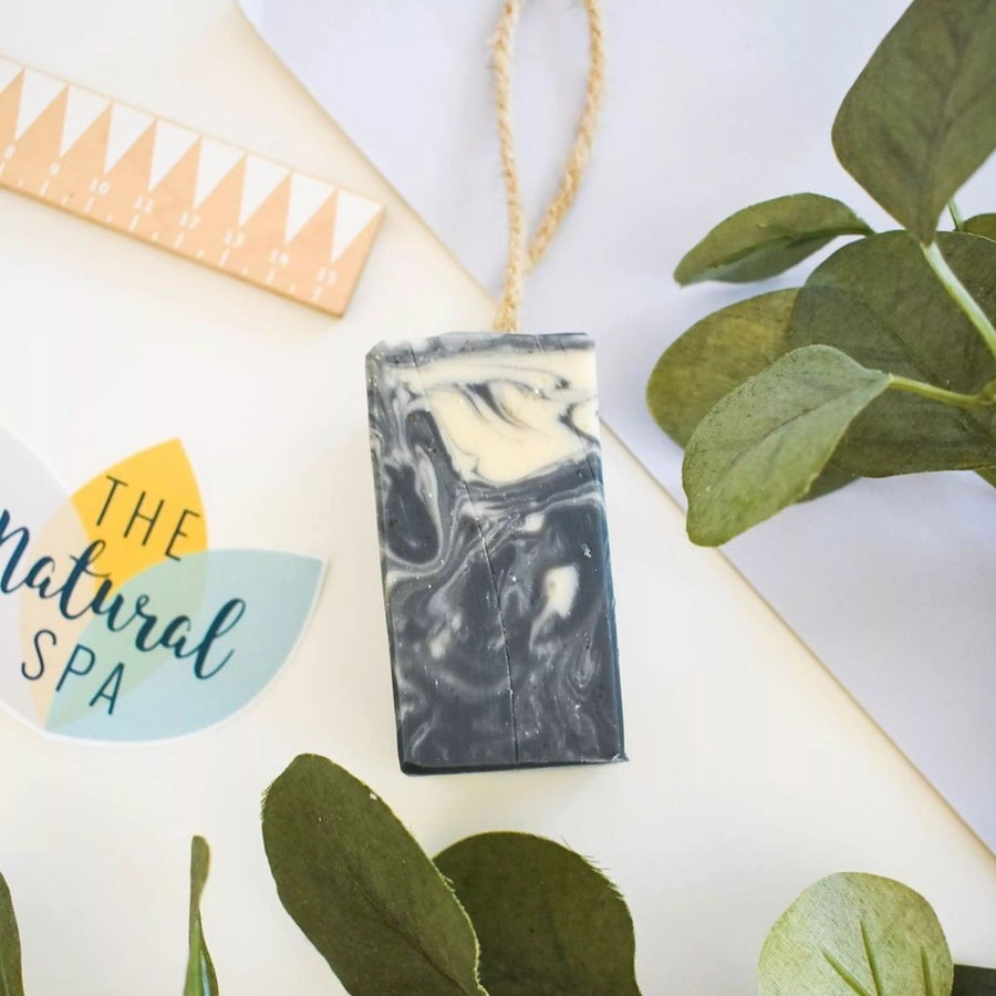 Black and white swirl design bar of soap with green leaves and 'The Natural Spa' logo on a white background