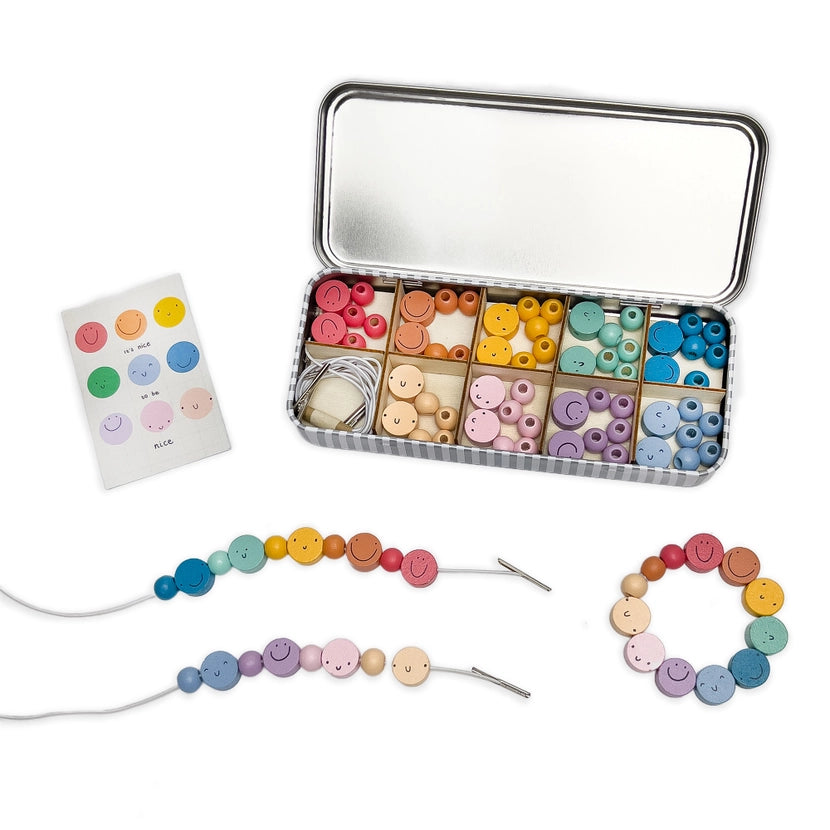 Colourful bracelet making kit in a metal tin with beads and a bracelet on a white background