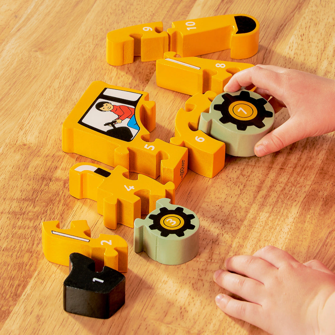 Children's educational toy digger puzzle with pieces numbered 1 to 10 on a wooden surface