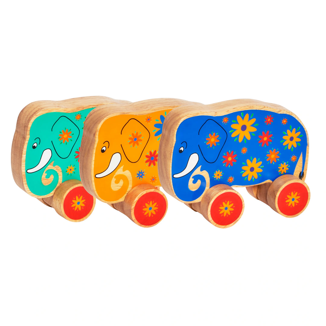 Lanka Kade 30th birthday limited edition push along elephants on wheels. The toys are made from rubber wood, painted blue, green and yellow with flower details and red wheels. Suitable for children from 10 months old. 