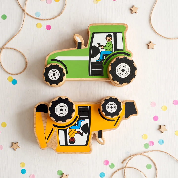 Two wooden toy tractor and construction vehicle cutouts arranged on a white surface with confetti, twine, and star decorations.