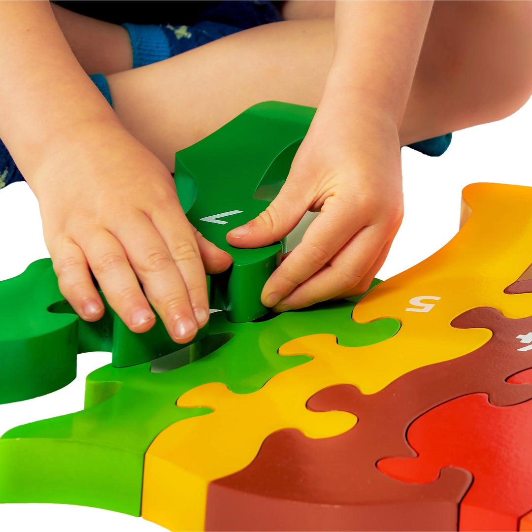 Children's hands playing with colourful wooden puzzle pieces on a white background