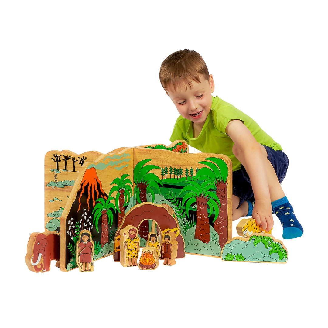 Child playing with a jurassic tropical themed play scene set with prehistoric figures on a white background