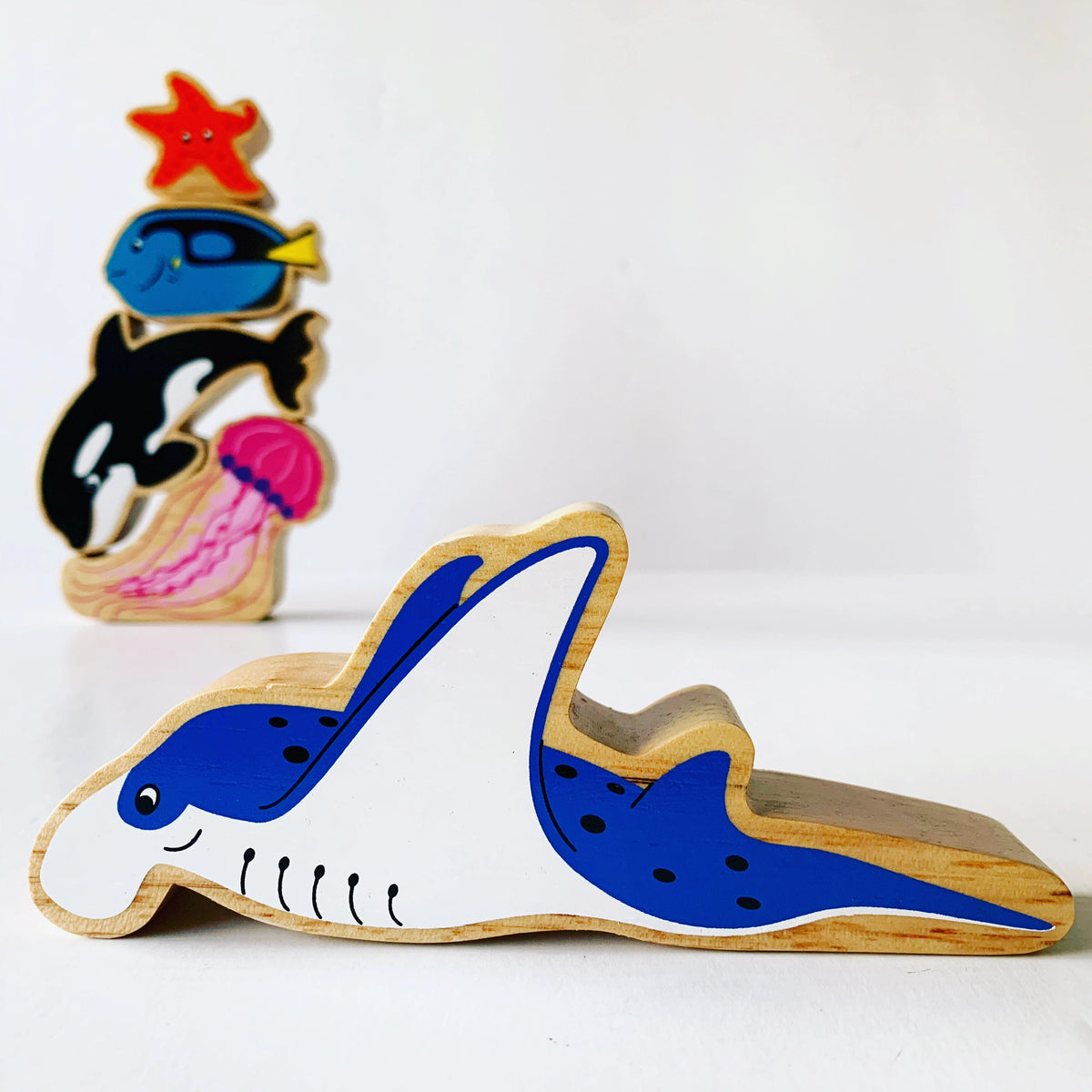 Lanka Kade Wooden Blue Manta ray wooden play figure with other ocean creatures in the background. Fo age 10 months and over 