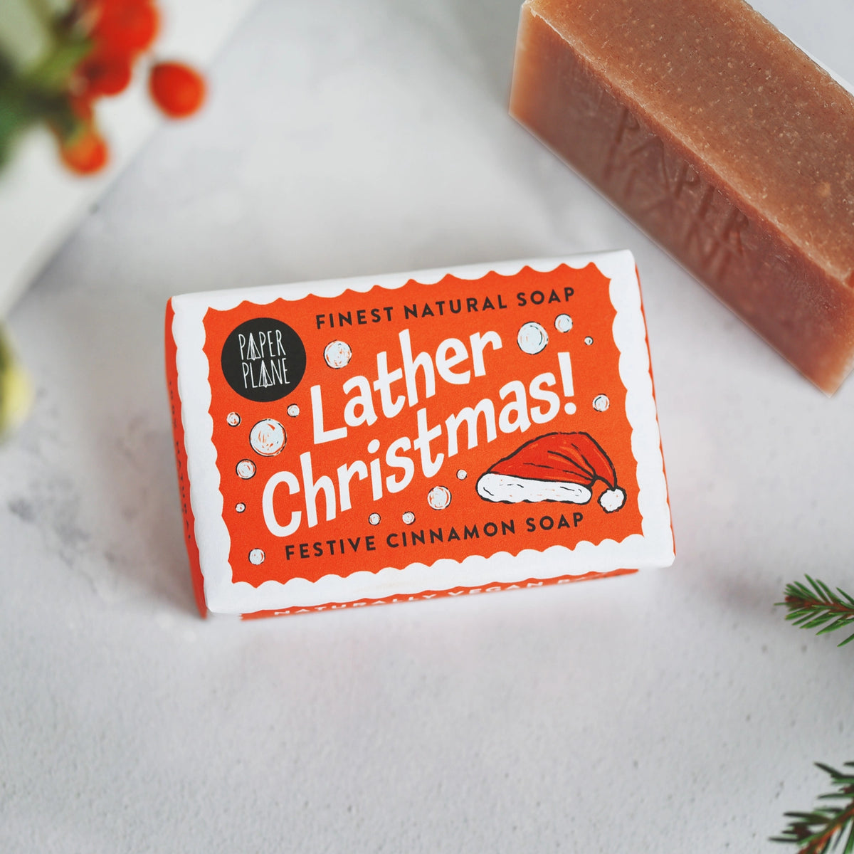 Bar of soap with a festive 'lather Christmas' label on a white surface