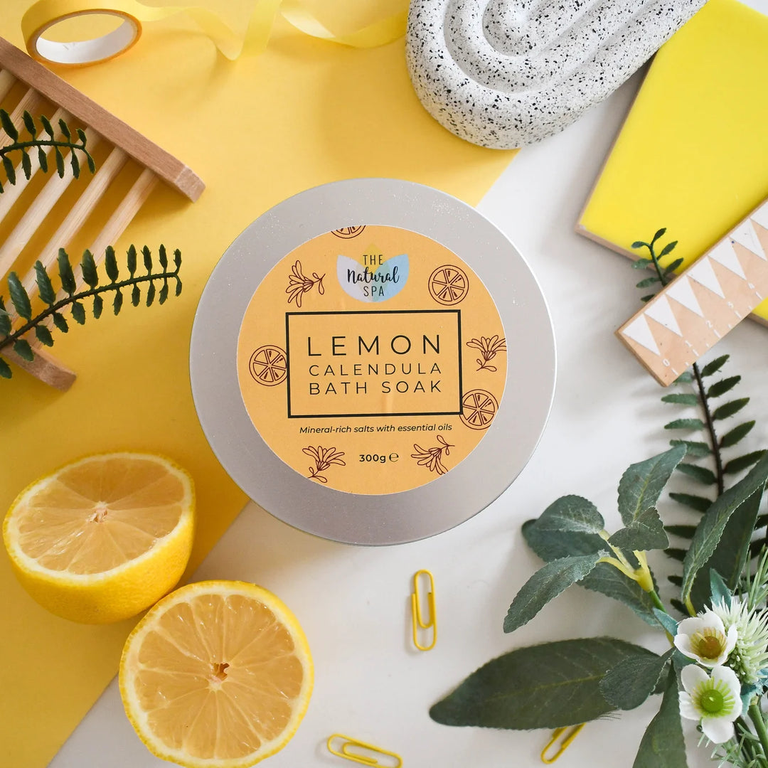 lemon calendula bath soak in an aluminium tin, placed on a yellow surface with decorative elements.