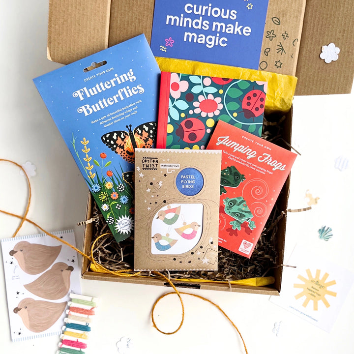 Educational children's craft kit with a notebook and paper craft activities in a hand stamped kraft gift box on a white background