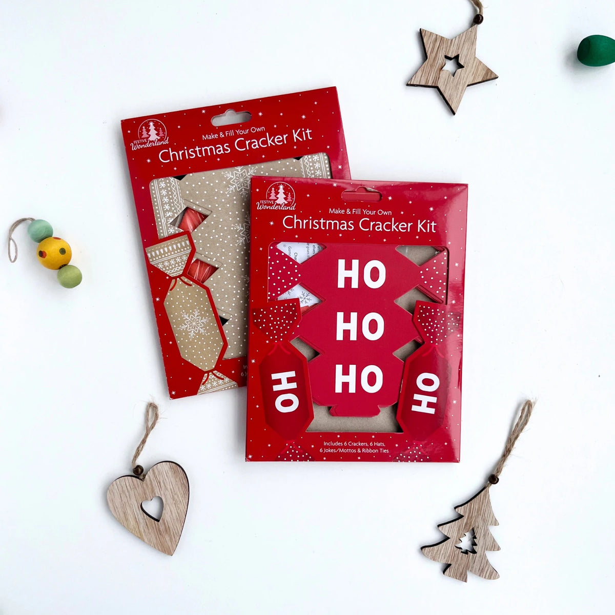 two make your own Christmas cracker kits in red packaging. One kit is read with a 'ho ho ho design' and the other is kraft brown with white snowflake design. 