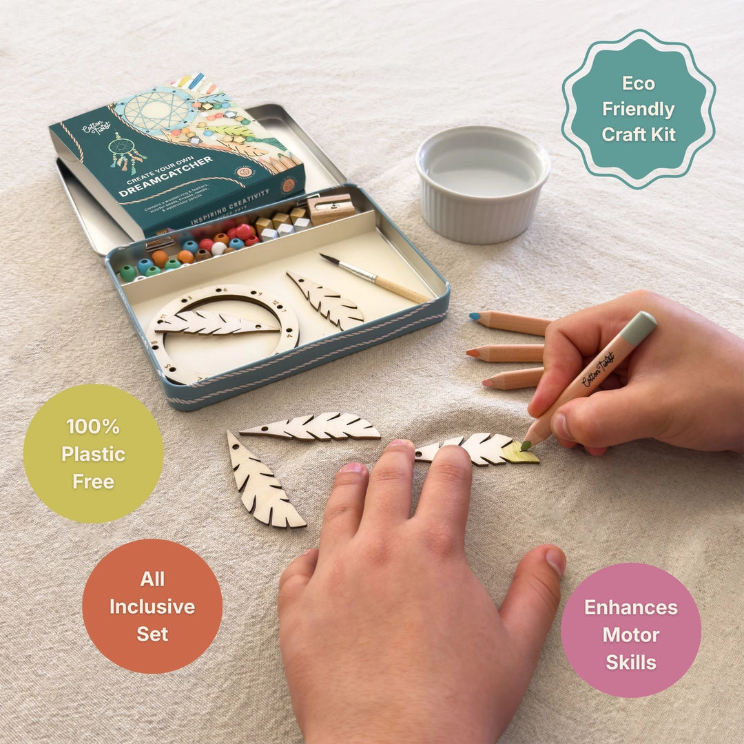 Eco Friendly Craft Kit shown in an open metal tin with wooden craft pieces, beads, and a box on a light fabric surface. Two hands are visible using the kit, with text callouts reading &