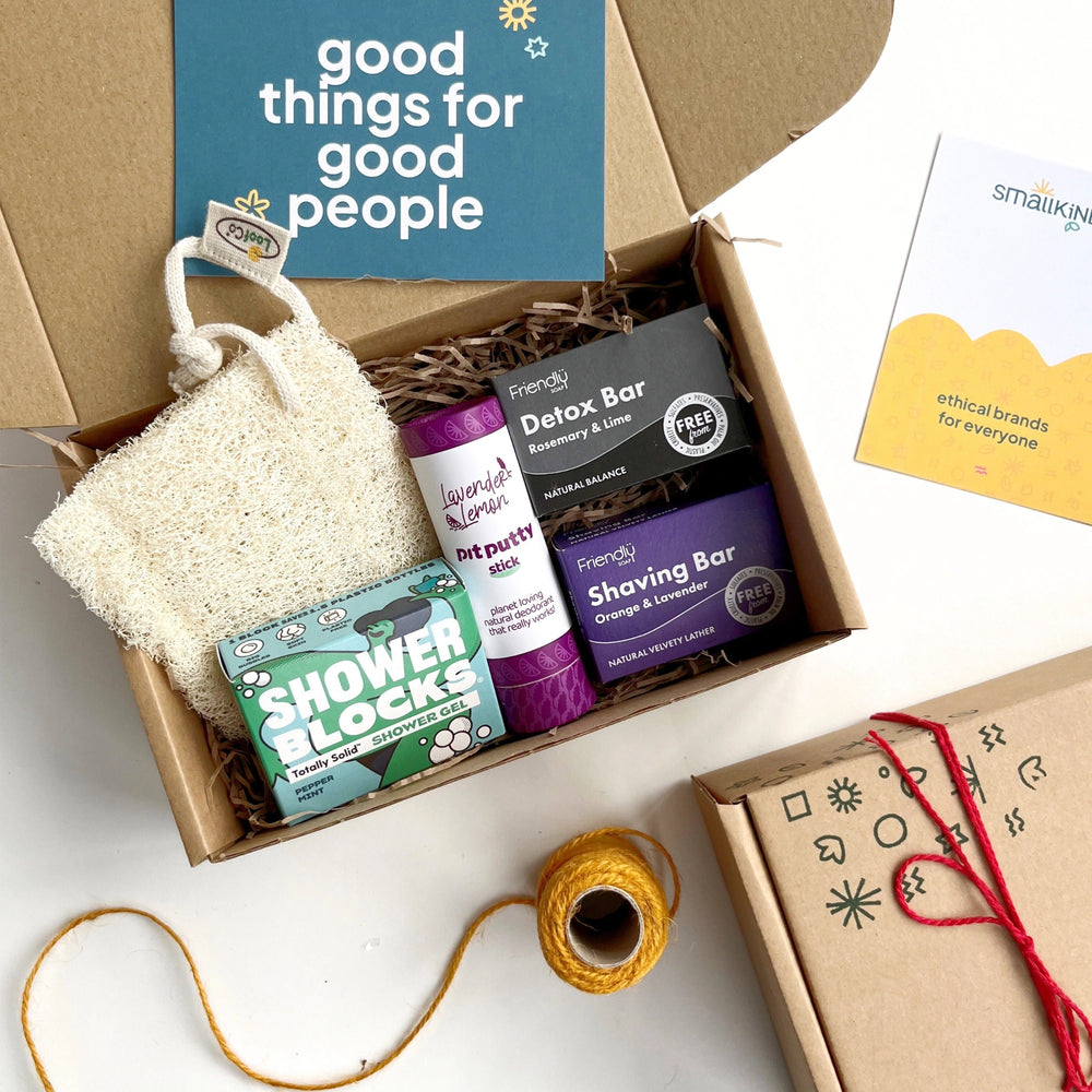 mens deluxe eco grooming box with a natural deodorant, detox soap bar, shaving soap bar, loofah and peppermint shower gel bar. The products have a blue and purple theme and the box is hand stamped and tied with red twine.