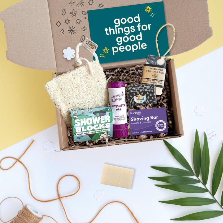 gift box with a selection of toiletries for men including soap bars, loofah and deodorant with a card which says 'good things for good people'
