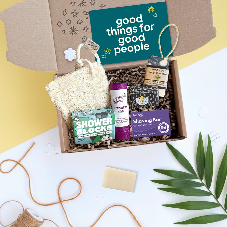 gift box with a selection of toiletries for men including soap bars, loofah and deodorant with a card which says 'good things for good people'