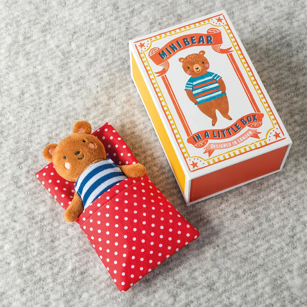 Small teddy bear in a striped shirt on a red polka dot blanket next to a box labeled 'Mini Bear in a Little Box'.