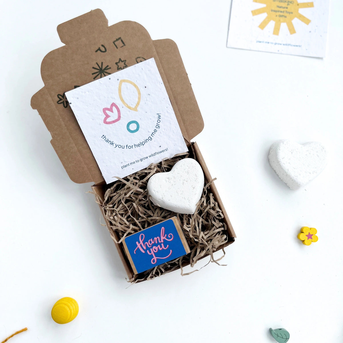 smallkind mini thank you gift box with a heart shaped natural bath bomb and a box of 'thank you' seedballs inside a hand stamped gift box. 
