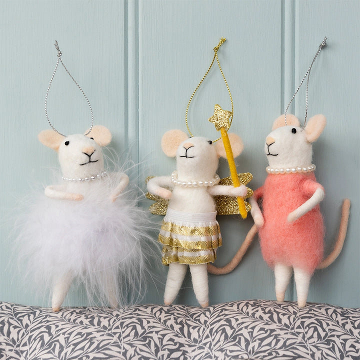 Three decorative mouse figurines in different outfits on a patterned surface with a light blue background.