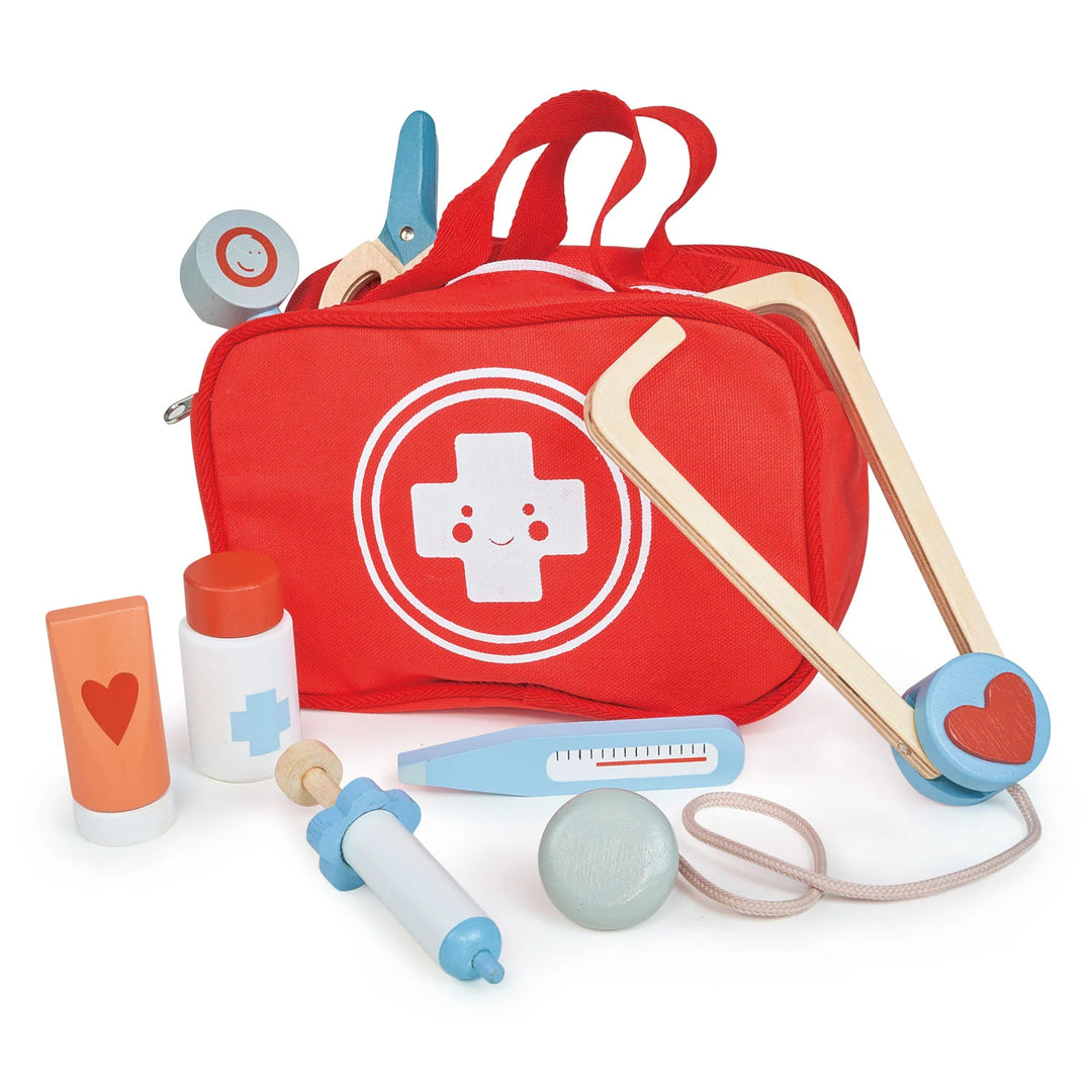 Red toy first aid kit with medical tools on a white background