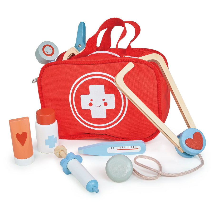 Red toy first aid kit with medical tools on a white background