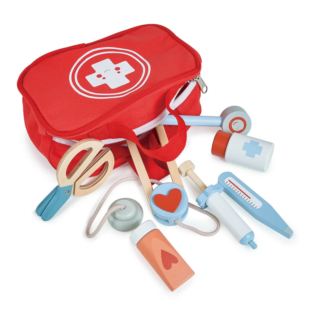 Red toy first aid kit with various medical tools on a white background