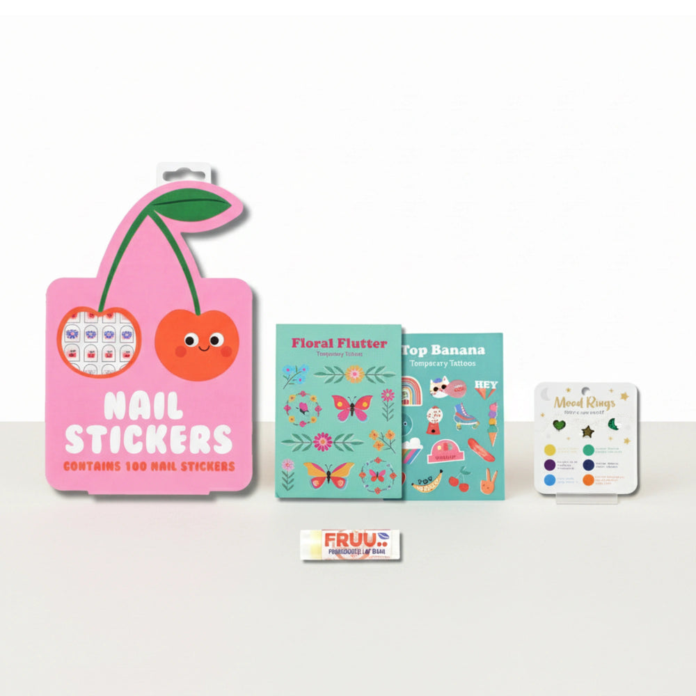 Set of nail stickers, temporary tattoos, mood rings and a lip balm from the Children's Nails + Beauty Gift boxon a light background 