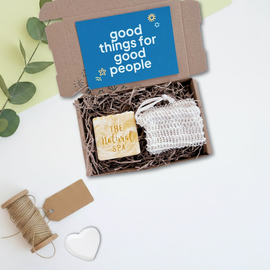 Gift set with soap and soap saver in a box labeled 'good things for good people' on a light background.