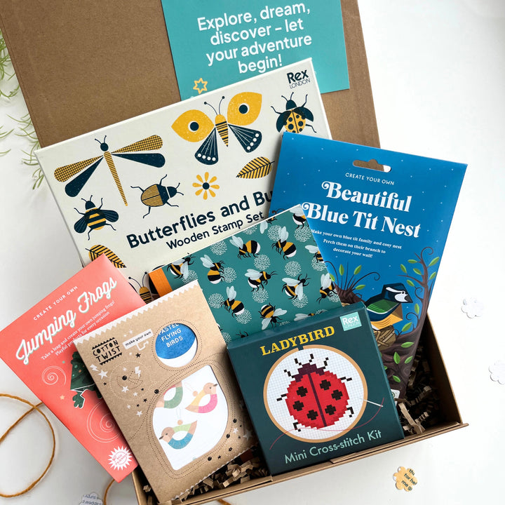 close up of several of nature-themed activity kits and crafts for kids in a keepsake box on a white background