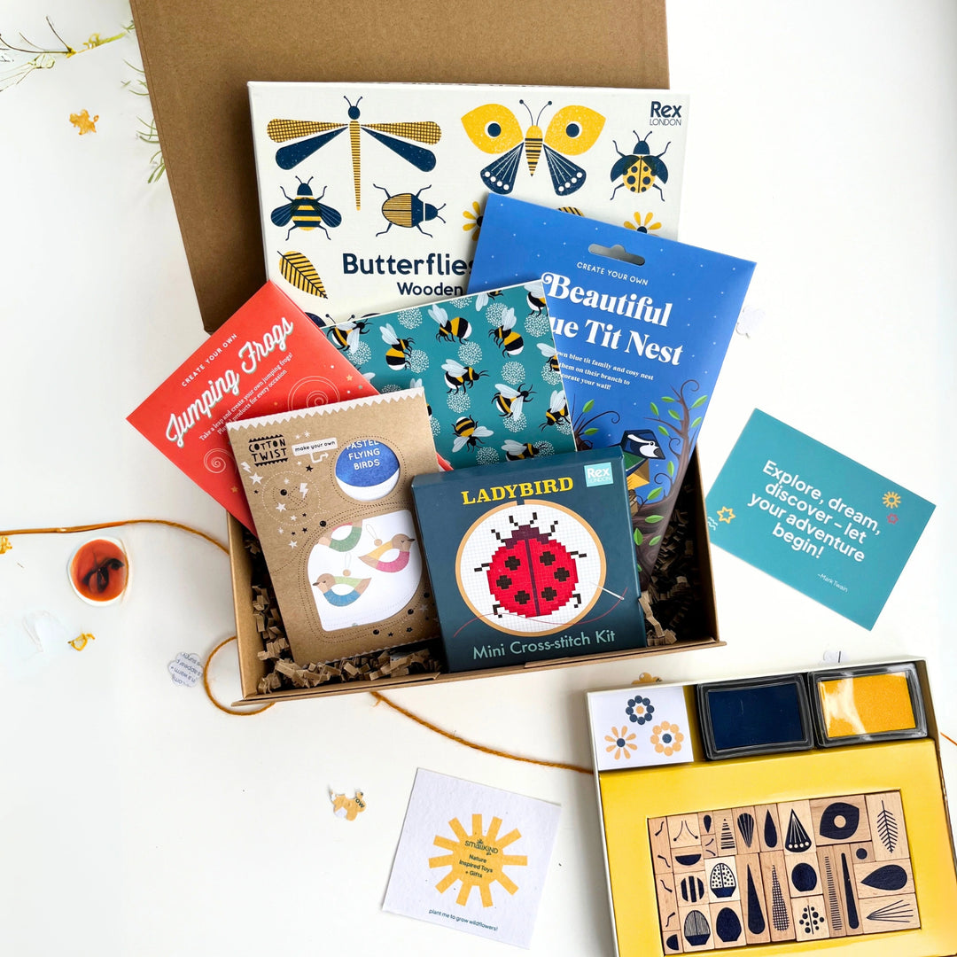 Collection of nature-themed activity kits and crafts for kids in a keepsake box on a white background