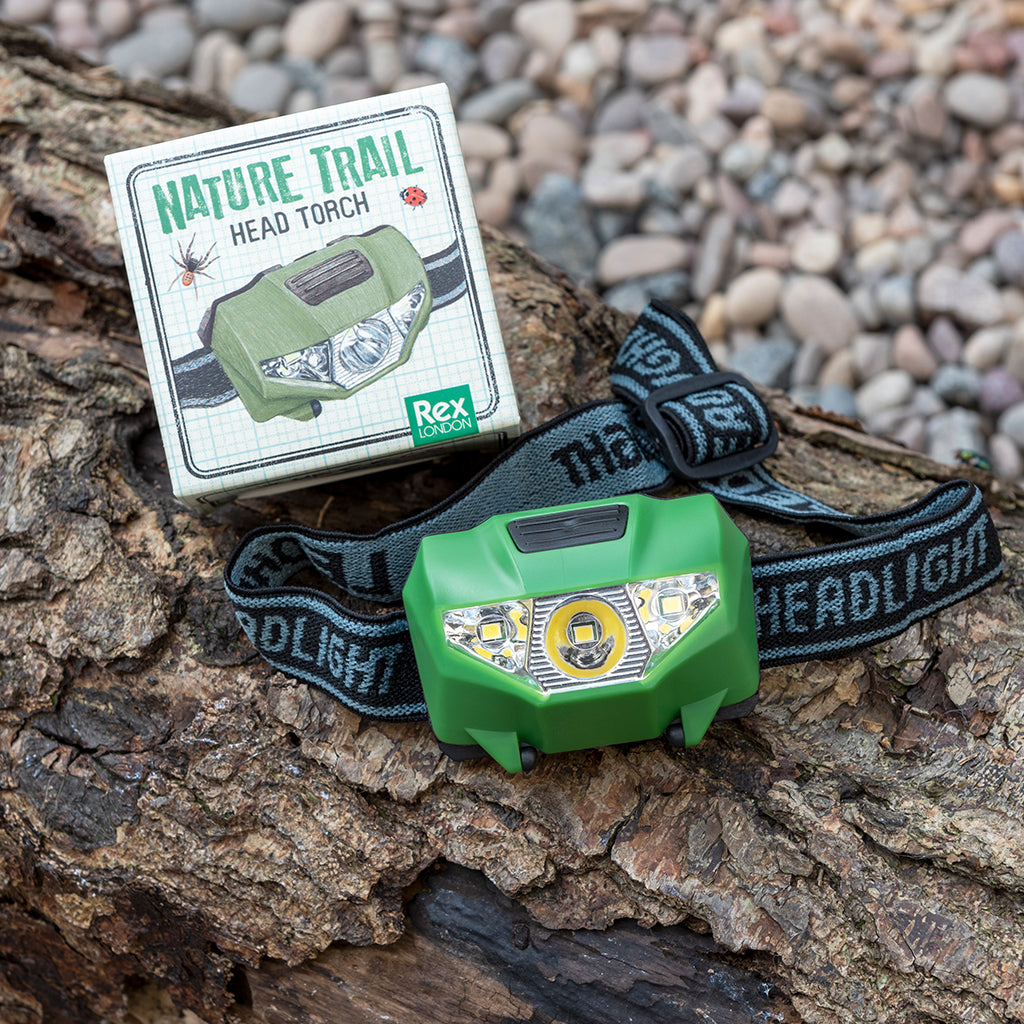 rex london childrens head torch with box on a rock outside. For children age 3+