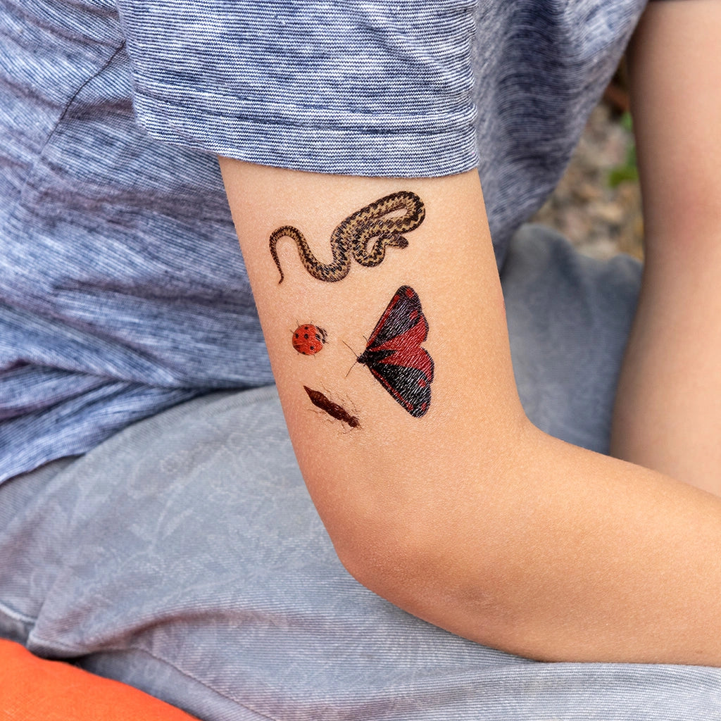 childs arm with four Nature trail temporary tattoos - snake, moth, cricket and ladybord -for children aged 3 and over. 