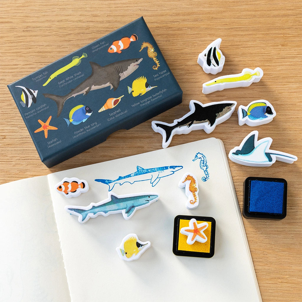 Set of ocean-themed stamps and stamp pad on a wooden surface