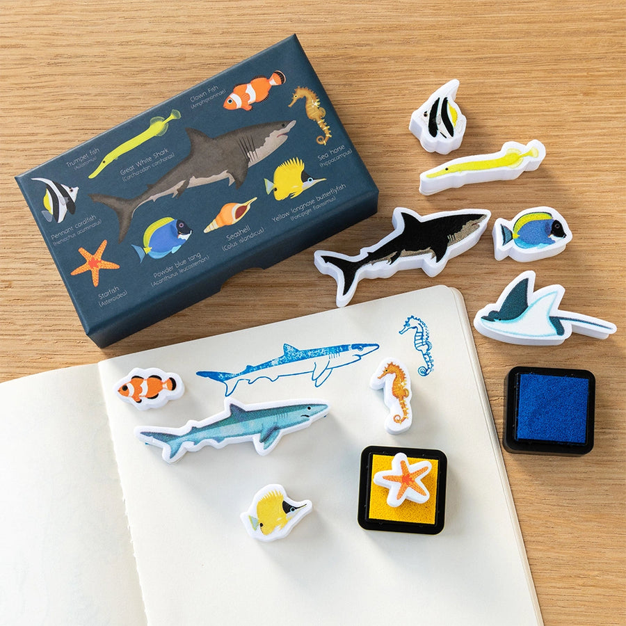 Set of ocean-themed stamps and stamp pad on a wooden surface